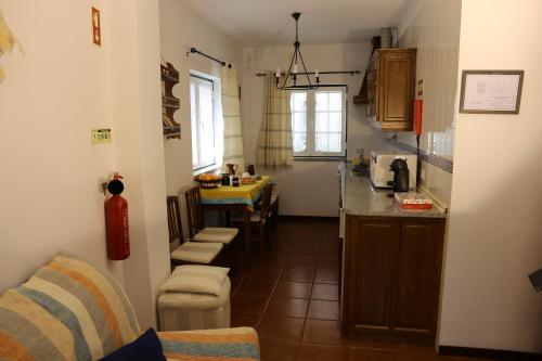 a small kitchen with a counter and chairs in it at Casa dos Teares in Aldeia das Dez