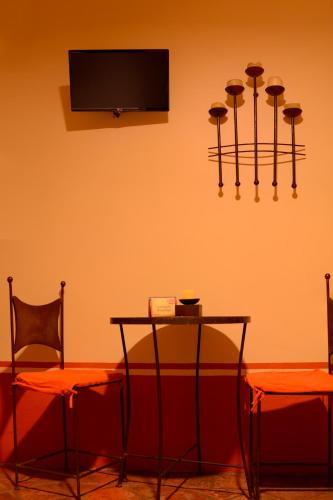 a room with a table and two chairs and a television at Hotel Boutique Tierra Magica in Tequila