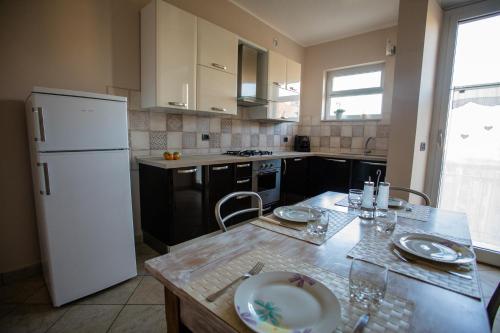 a kitchen with a table and a white refrigerator at Terrazza di Pinerolo in Pinerolo