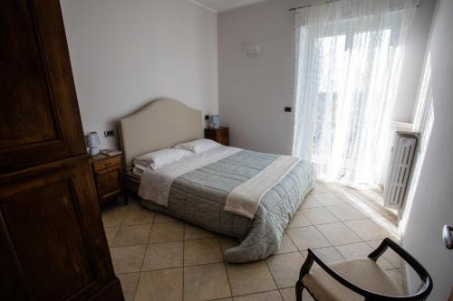 a bedroom with a bed and a window and a chair at Terrazza di Pinerolo in Pinerolo