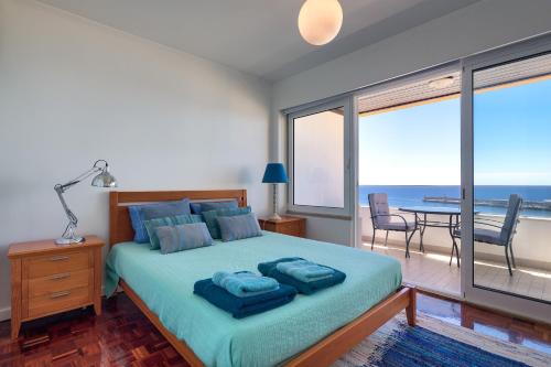 a bedroom with a bed with a view of the ocean at avenida arriaga 806 top floor in Funchal