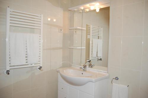 a white bathroom with a sink and a mirror at Casinhas do Gerês in Geres