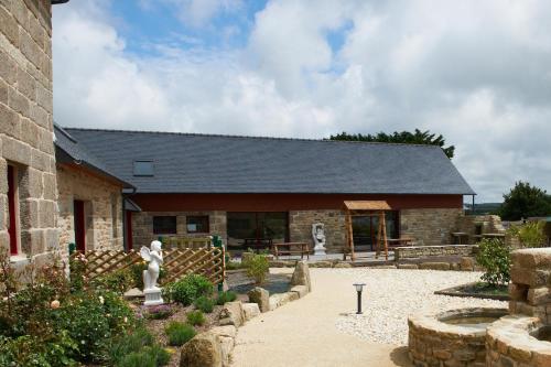 a large stone building with a garden in front of it at Domaine de Kerzuat in Plouarzel