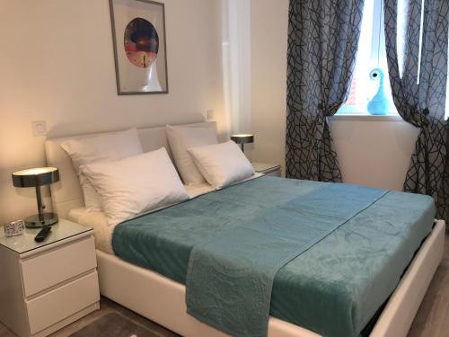 - une chambre avec un lit et une couverture bleue dans l'établissement Candille, à Nice