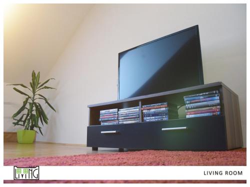 a black entertainment center with a television and dvds at ACO Living - A Cheap Overnight in Klagenfurt