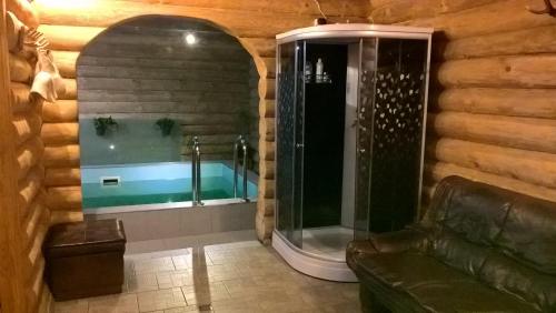 a bathroom with a glass shower in a log cabin at Vizbulites in Pulkarne