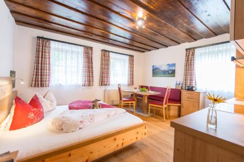 a bedroom with a bed and a dining room at Biohof Maurachgut in Bad Hofgastein