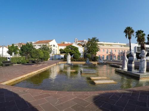 una fontana nel mezzo di un cortile con edifici di Apartamento Xelb a Silves