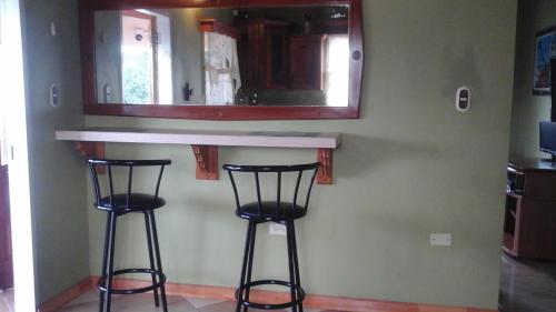 eine Küche mit zwei Barhockern und einem Spiegel in der Unterkunft Islanders Place in Golden Grove
