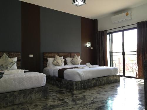 1 Schlafzimmer mit 2 Betten und einem großen Fenster in der Unterkunft Baan Rai Phufah Resort Chiangrai in Ban Pa Ruak