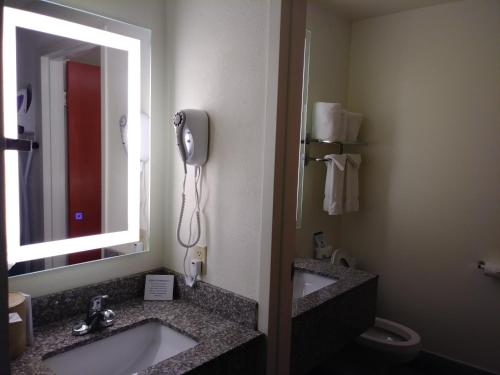 a bathroom with two sinks and a mirror and a toilet at Quality Inn & Suites Fort Collins in Fort Collins