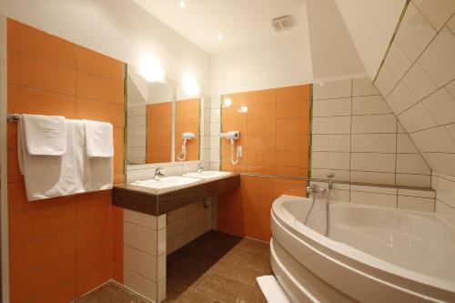 a bathroom with a tub and a sink and a bath tub at Hotel Preuss im Dammtorpalais in Hamburg