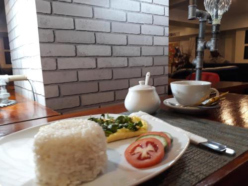a table with a plate of rice and a slice of tomato at Spaces Hotel Makati in Manila