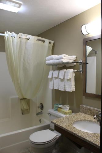 a bathroom with a toilet and a sink and a mirror at Super 8 by Wyndham Kearney in Kearney