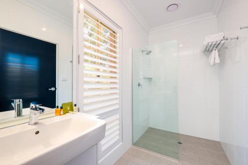 a bathroom with a shower, sink, and mirror at Commercial Golf Resort in Albury