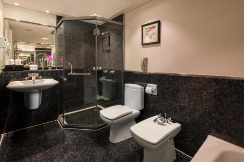 a bathroom with a toilet and a sink and a shower at Overseas Chinese Hotel Wenzhou in Wenzhou