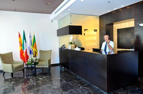 a man standing at a counter in a lobby at Golden Crown Old City Hotel in Nazareth