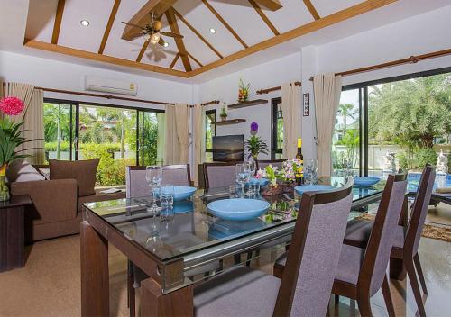 a dining room and living room with a table and chairs at Victoria Villa in Na Jomtien