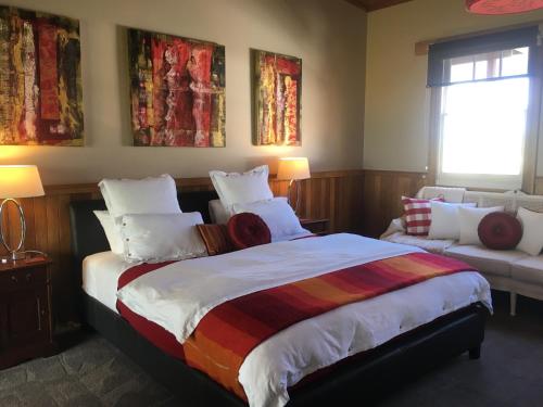 a bedroom with a large bed and a couch at Cable Station Accommodation in Stanley