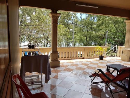 eine abgeschirmte Veranda mit einem Tisch und Stühlen in der Unterkunft JN sunflower residence in Le Morne