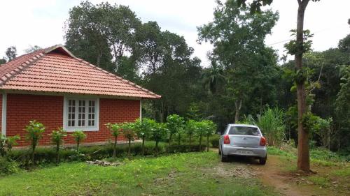 a small car parked in front of a house at Marsim Holiday Resort in Vythiri