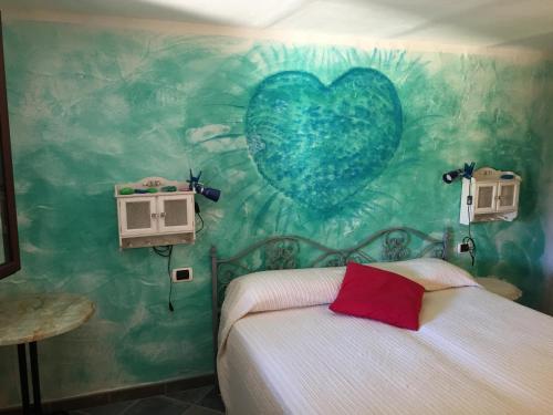 een slaapkamer met een op de muur geschilderd hart bij Casa Mare Tamerici in San Teodoro