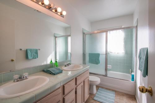 a bathroom with two sinks and a toilet and a mirror at Red Rock Vacation Villa in Las Vegas