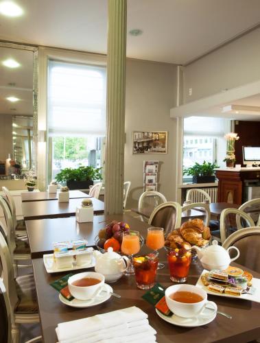 a dining room with a table with food on it at Hotel Restaurant Les Capucins in Belfort