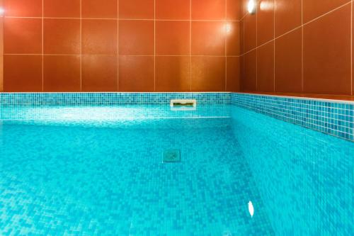 a large swimming pool with blue tiles on the wall at Onega Castle Hotel in Petrozavodsk