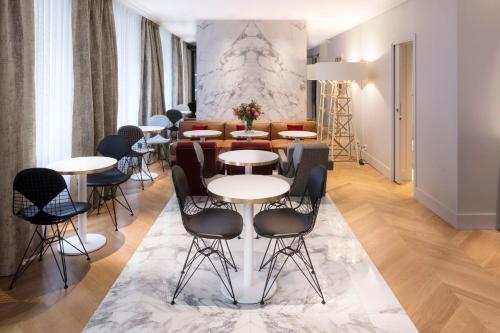 a living room with a table and chairs at Nouvel Hôtel Eiffel in Paris