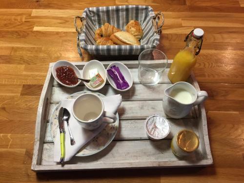 ルマンにあるCabane du Circuitのカップと皿が載ったトレイとパンの入ったバスケット