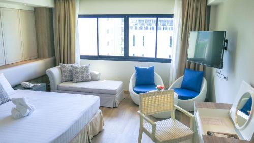 a room with a bed and a tv and a couch at Hiran Residence in Patong Beach