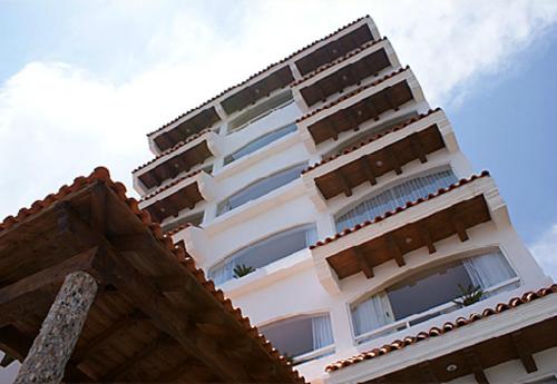 a tall white building with a tile roof at Hotel 9 Manantiales in Chignahuapan