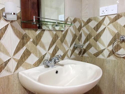 a white sink in a bathroom with a mirror at Aroma Heaven Homestay in Ella