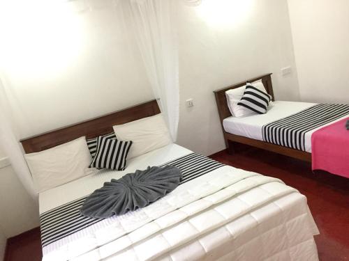 two beds in a small room withskirts at Aroma Heaven Homestay in Ella