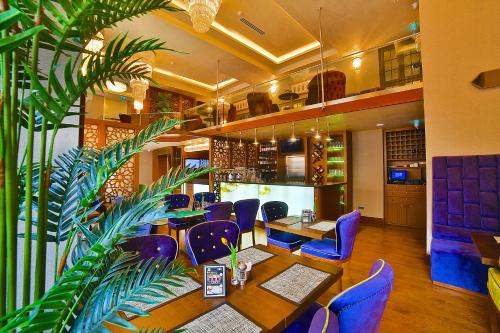 a restaurant with purple chairs and a table and a plant at Hotel Momento Golden Horn in Istanbul