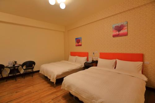 a hotel room with two beds and a table at Miyama Bed and Breakfasts in Chishang