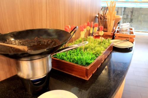 a wok on top of a counter with a garden at Fame Hotel Sunset Road in Kuta
