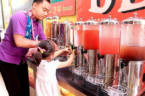 a man and a little girl standing next to a blender at Fame Hotel Sunset Road in Kuta