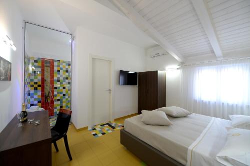 a bedroom with a bed and a desk and a mirror at X Hotel in Saviano