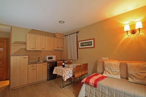 a kitchen with a couch and a table in a room at Hotel-Aparthotel El Reyno in Sallent de Gállego