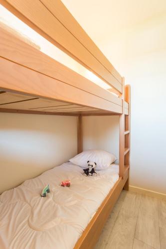 a bunk bed with two toys on the bottom bunk at Résidence Pierre & Vacances Le Clos d'Eguisheim in Eguisheim