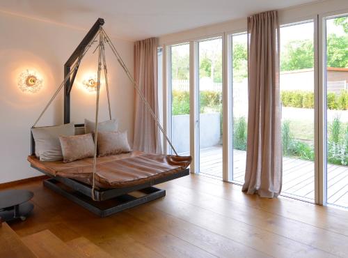 um quarto com um baloiço num quarto com janelas em Wasserwerk Bad Saarow em Bad Saarow
