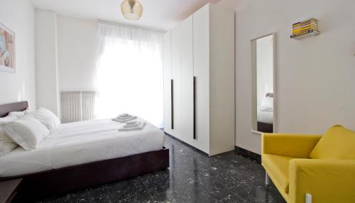 1 dormitorio con 1 cama y 1 silla amarilla en Italianway-Alzaia Naviglio Pavese en Milán