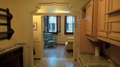 a hallway leading to a room with a chair and window at Cà Formosa in Venice