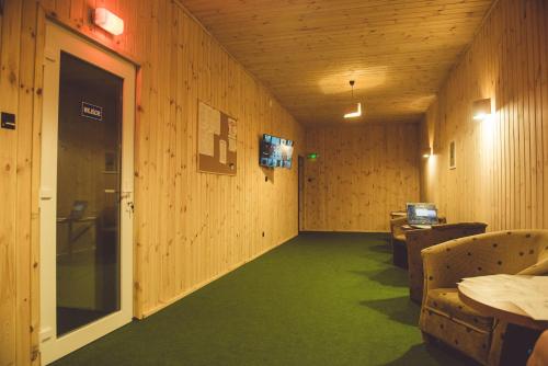 a room with wooden walls and a green carpet at Hotel Odejewscy in Chojnice