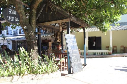 a restaurant with a sign in front of a tree at Y Not Laos Hostel in Luang Prabang
