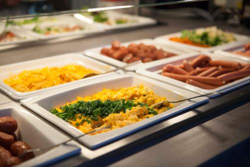 un buffet lleno de diferentes tipos de comida en bandejas en Blue Mountain Resort, en Szklarska Poręba