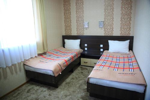 two beds in a small room at Aska Hotel in Naryn