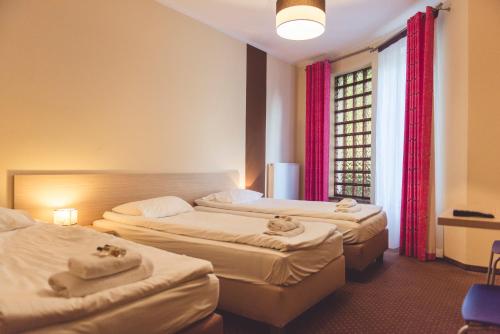 a hotel room with two beds and a window at Hotel Odejewscy in Chojnice